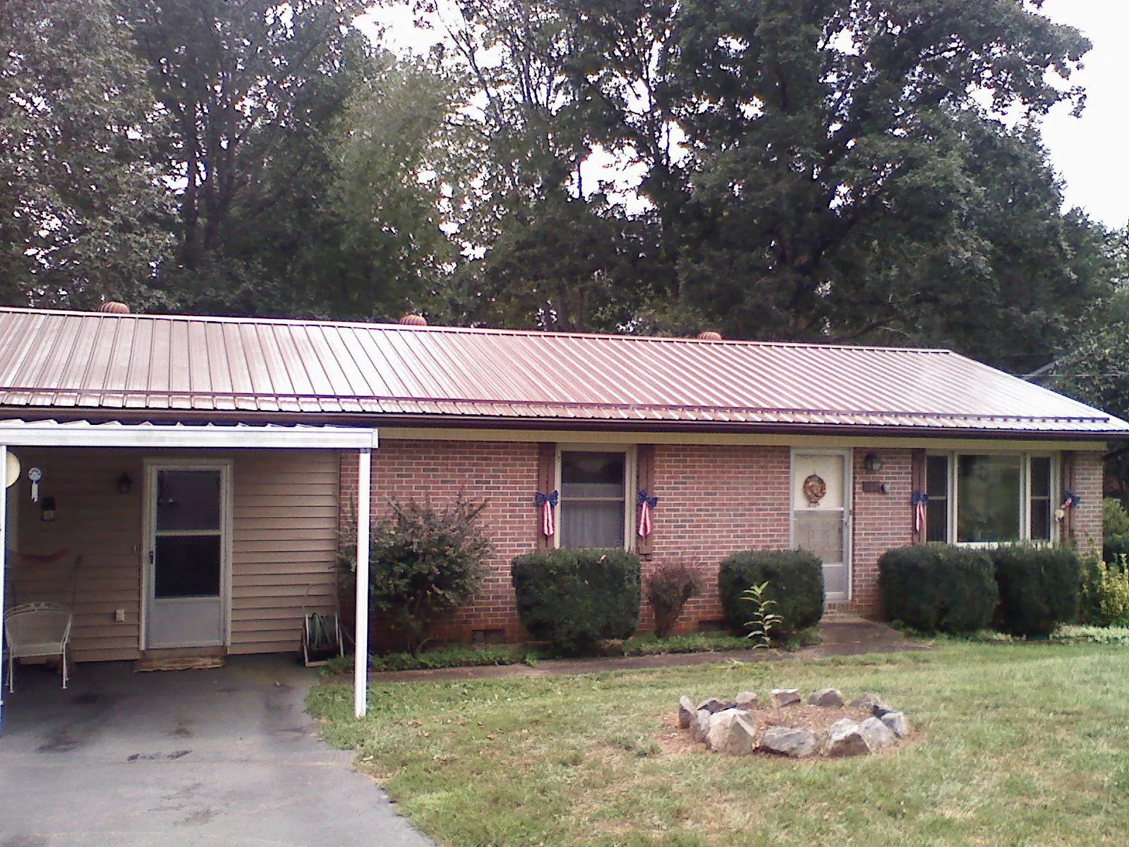 Bronze metal roof and carport on a brick ranch home — Roof Repair work by our crew in Bishopville