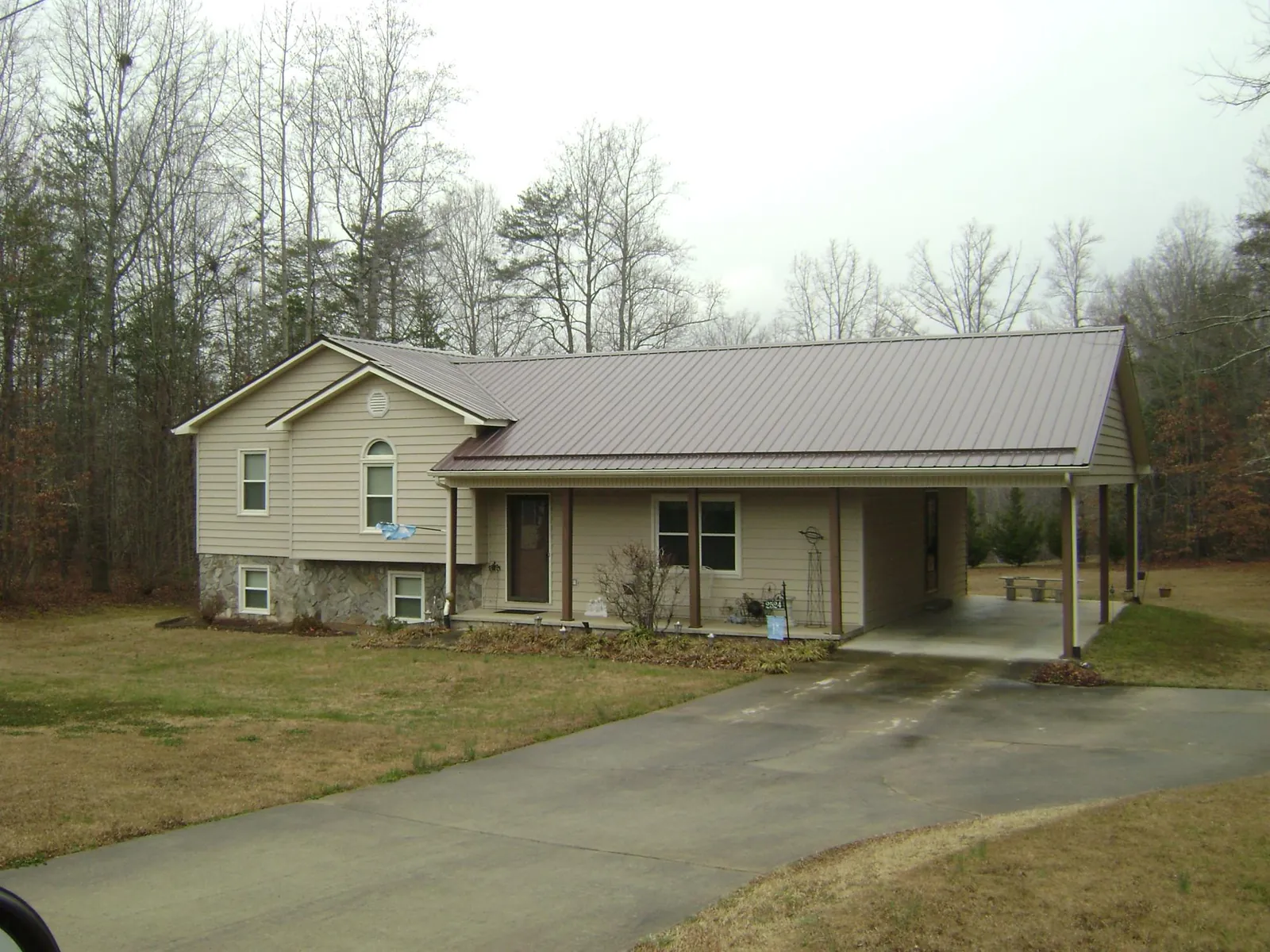 Brown metal roof on a tan split level home with an attached carport in Bishopville